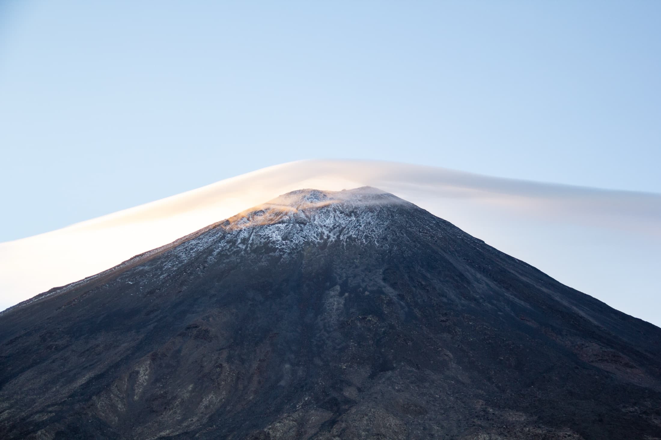 The volcanic cone of Ngauruhoe capped by a lenticular cloud at first light